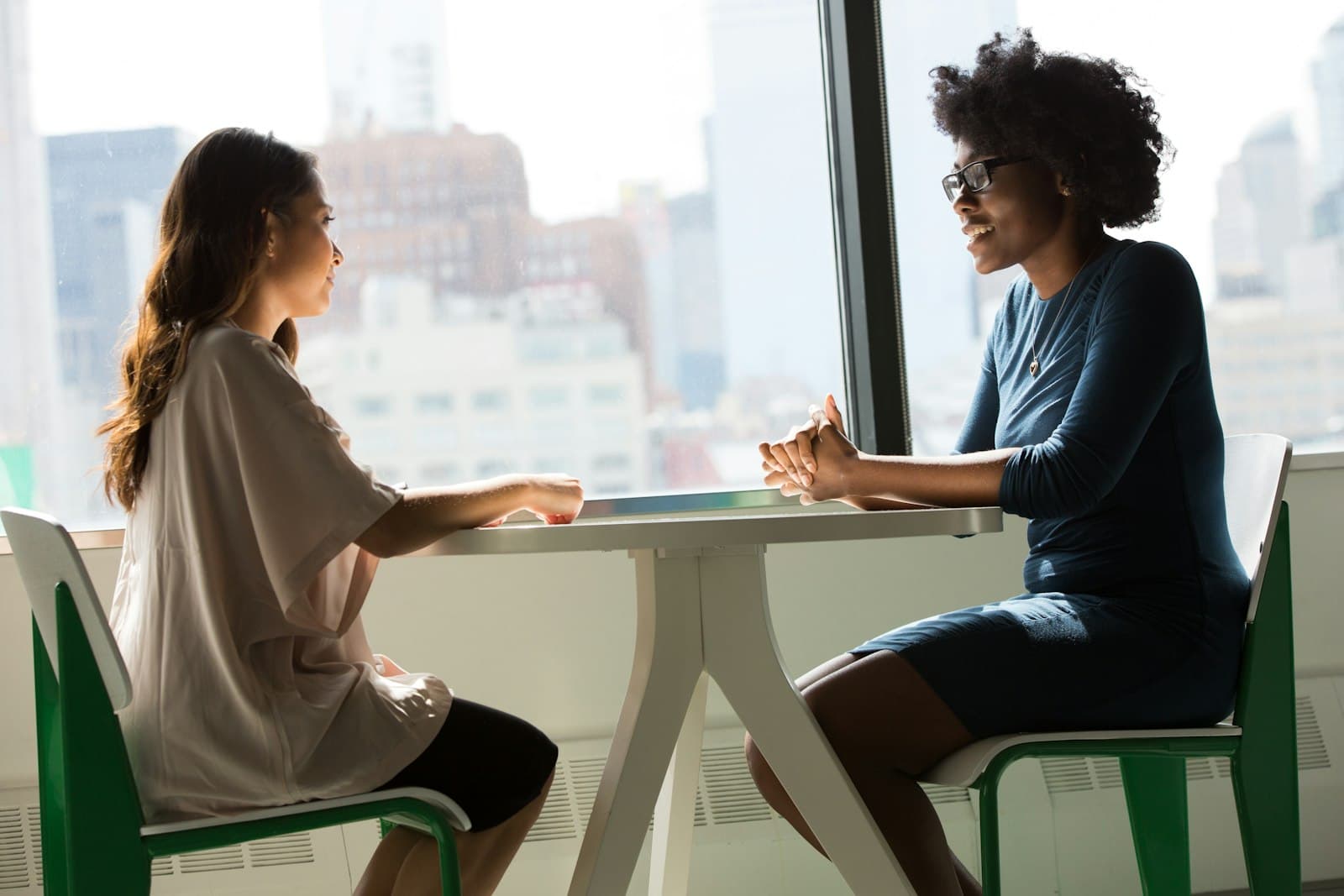 Two women in conversation at a table, like an interview