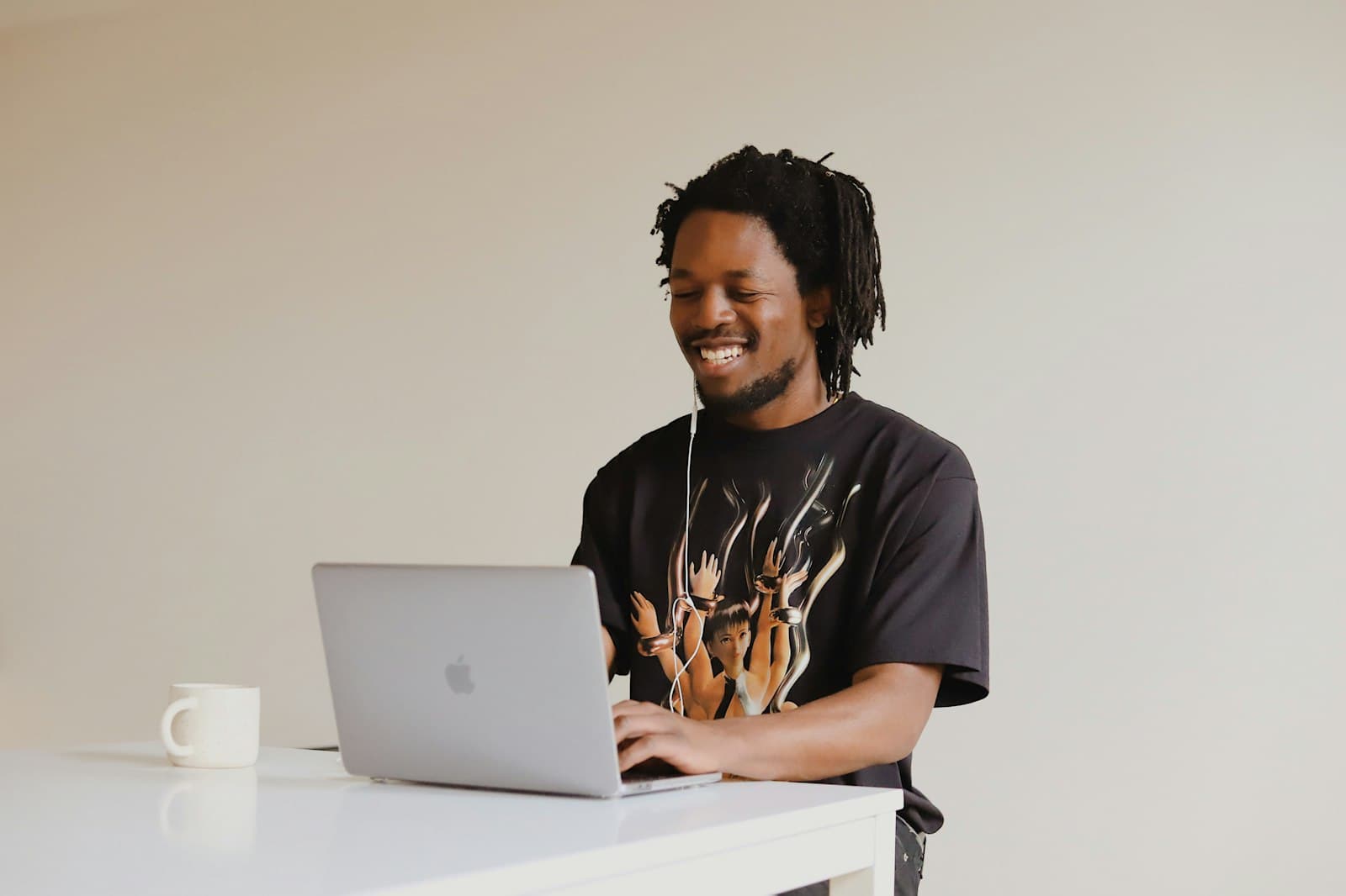 Young man smiling while typing on a laptop